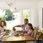family at home eating meal in kitchen together